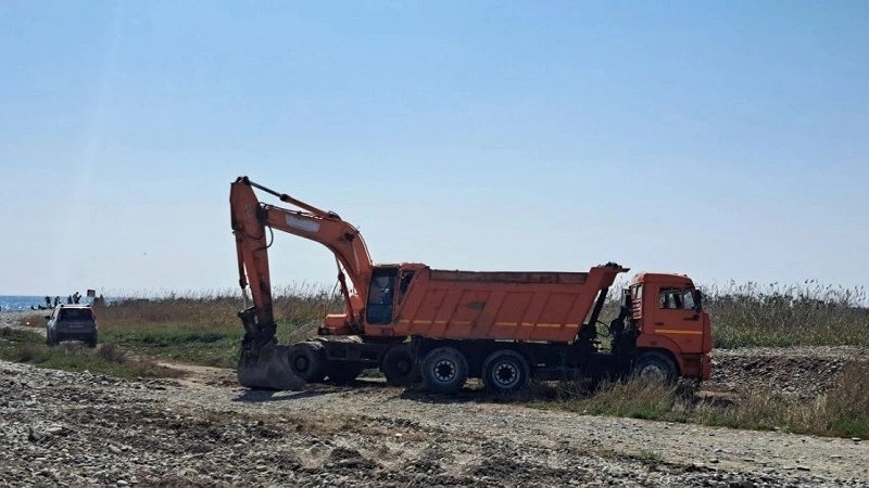 В Новороссийске экскаватор пересыпает гальку с берега моря на территорию лагуны