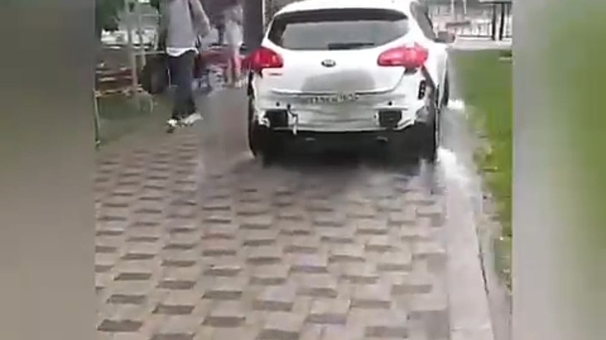 Главная картинка новости: В сильный дождь новороссийцы спасали свои авто на тротуарах. Видео