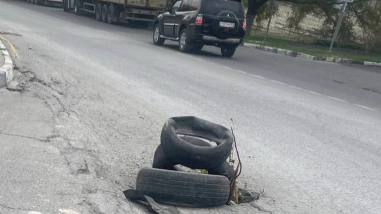 Главная картинка новости: В Новороссийске яму на дороге просто закрыли шинами и ветками